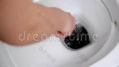 用马桶刷清洁马桶。女人用马桶刷洗手。关闭马桶内的冲洗水